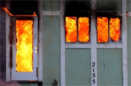 Structure Filled with Fire Inside Seen Through Window and Doors