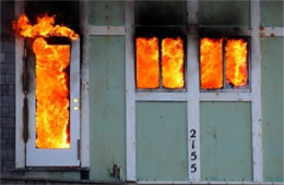 Structure Filled with Fire Inside Seen Through Windows and Door