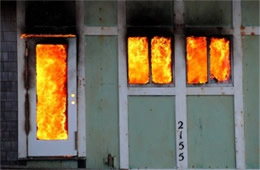 Structure Filled with Fire Inside Seen Through Window and Doors