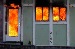 Structure Filled with Fire Inside Seen Through Windows and Doors