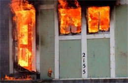 Structure Filled with Fire Inside Seen Through Windows and Door