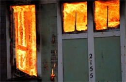 Structure Filled with Fire Inside Seen Through Windows and Doors