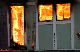 Structure Filled with Fire Inside Seen Through Windows and Door