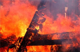 Fallen House Beams Engulfed in Flame