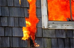 Structure Filled with Fire Inside Seen Through Window and Burned through Wall 