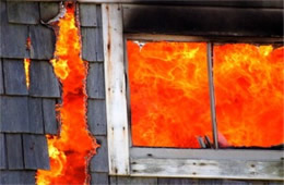 Structure Filled with Fire Inside Seen Through Window and Burned through Wall 