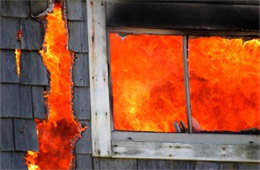 Structure Filled with Fire Inside Seen Through Window and Burned through Wall 